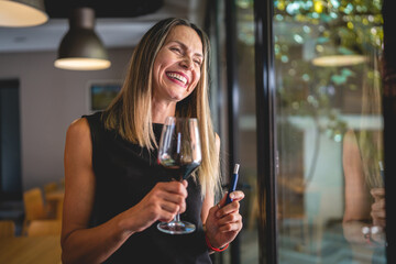 one woman with glass of red wine and electronic cigarette device