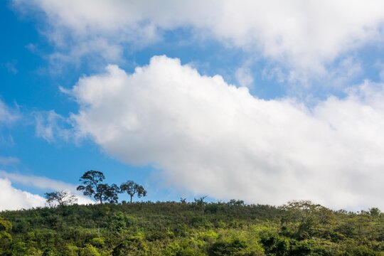 Clouds over the mountains with few trees at Macuco town, State of Rio de Janeiro, Brazil.