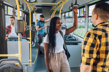 Multiracial female friends talking while riding a bus in the city