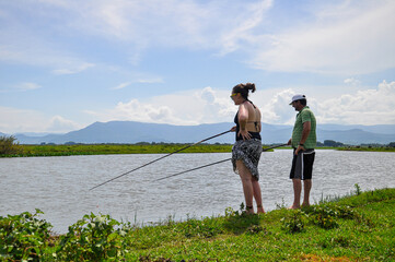 Couple fishing Tres Forquilhas river, next to Itapeva Lagoon. Mountains on background. Capão da...