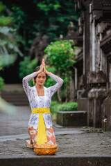 attractive balinese woman in kebaya do prayer and make an offering to god in the morning