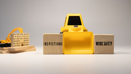 inspections, work safety , written on wooden sticks. Business machine and white background concept....