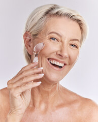 Mature, portrait and woman using rose roller on face for skincare massage and beauty spa routine. Feminine, selfcare and cosmetics for anti ageing facial treatment with white studio background.