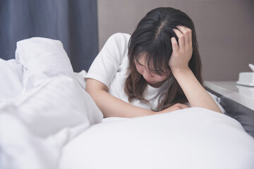 女性がベッドで頭を抱えている  bedroom