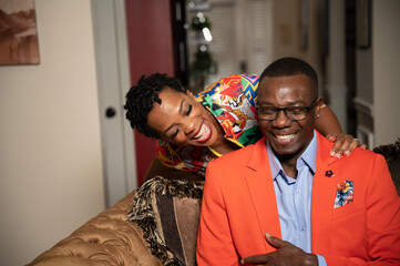 Black couple laughing before heading out on date night to celebrate their anniversary