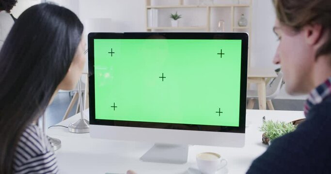 Green screen, mockup or chroma key on computer and digital technology with tracking markers for marketing, advertising or promotion. Business team working on graphic design in a startup tech company