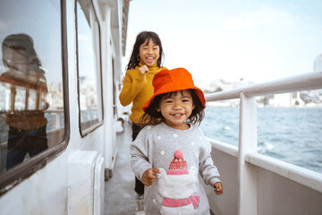 happy two little girl running around the ferryboat
