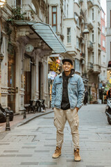 Fototapeta na wymiar man with denim jacket smiling to camera full body portrait at the alley old town