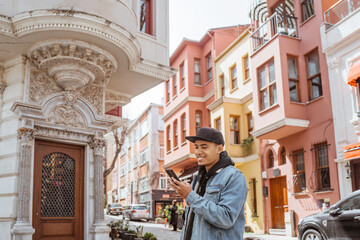 asian male using smart phone while exploring beautiful city in turkey