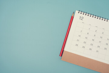 close up of calendar and pencil on the blue table background, planning for business meeting or travel planning concept