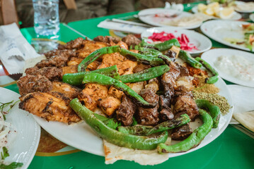 close up of kebab meat platter on plate with chilli and onion