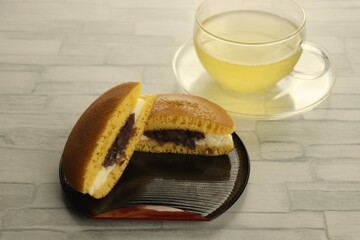 半月オリベ盆に盛られたカットされたどら焼きと緑茶
