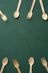 Plastic free set bamboo spoon and fork on dark green background.Zero waste disposable kitchen ware