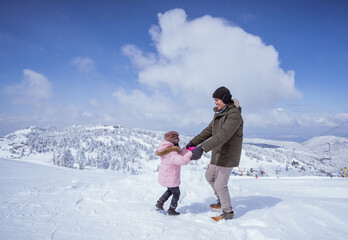 happy father and daughter in the snow enjoying their time on top of the uludag mountain