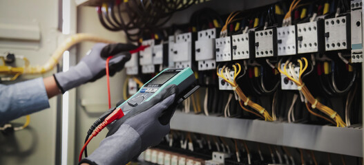 Electricity and electrical maintenance service, Engineer hand holding AC multimeter checking...