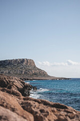 Beautiful seashore with lagoon sea and waves in front of the Cape Greco mountain