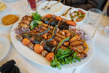 close up of kebab meat platter on plate with chilli and onion