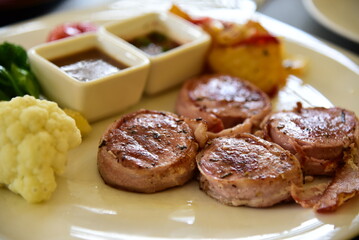 Lump meat with black pepper sauce and spinach on a ceramic dish.