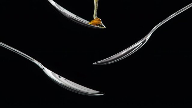 Close up Slow motion Honey Drip drop on spoon isolate on back background. 3D animation. Food drink concept. selective focus.