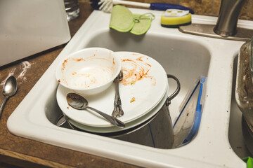 Dirty dishes piled in sink