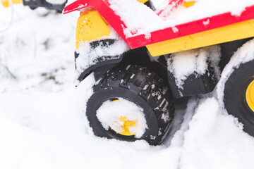Snowy toy dumptruck, toy in the cold, winter fun for children, plastic material, fossil fuels