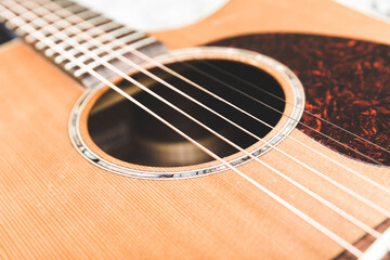 Steel strings and details on an ornate acoustic guitar