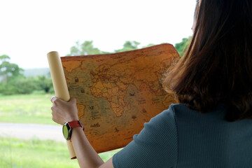 young woman's hand holding a map travel to study travel routes around the world background Picture...