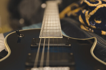 Close up of electric guitar strings, neck, and pickups