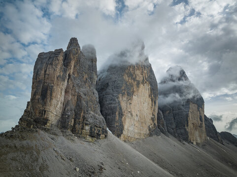 Cloudy day after the storm in the Dolomites mountains with mountain peaks looking up from the fog, mist, and clouds. 