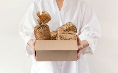 Woman holding a box wrapped with environmental friendly paper bubble wrap. Products packed with...