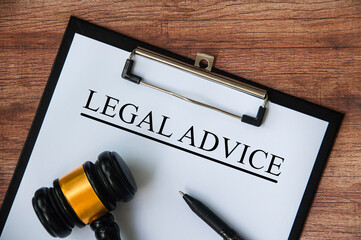 Legal advice text on white paper on a clipboard with gavel and pen. Legal and law concept