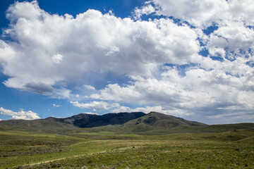 Fototapeta premium Cloudy blue sky over mountain and green valley