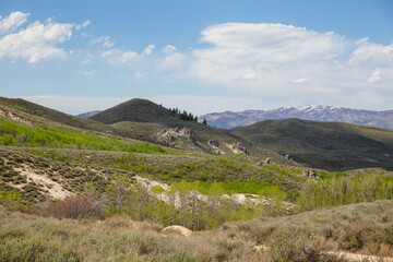 Green rolling hills and blue sky with clouds
