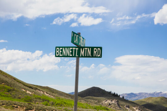Cat Creek meets Bennett Mtn, Rd street signs under blue sky with clouds. Near Prairie and Fairfield, Idaho.