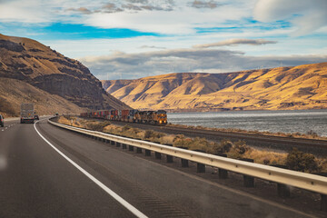Train on tracks near highway I-84 in the Columbia River Gorge (Oregon, USA)