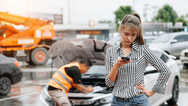 Asian woman she was using her smartphone to call out car insurance on the road