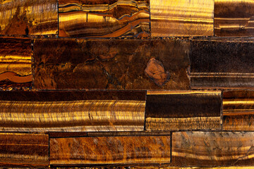 Tigers Eye Golden semi precious stone background, texture as part of project. Material for unique interior, exterior home decoration. Precious material as floor tiles and ceramic wall tiles surface.