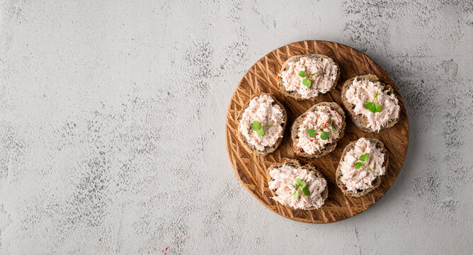 bruschetta with tuna pate, fish rillettes on concrete background, top view, copy space