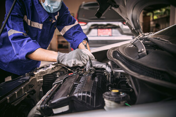 Car care maintenance and servicing, Close-up hand technician auto mechanic using the wrench to...