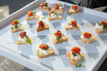 A view of a tray of hors d'oeuvres, featuring goat cheese canape.