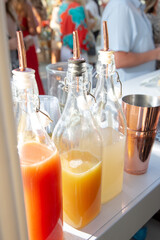 A view of a few bottles filled with fruit juice mixers, seen at a local catered event bar area.