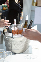 A view of several wine bottles chilled inside a metal tub filled with ice, seen at a local wine tasting event.