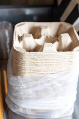 A view of a large stack of biodegradable cup carriers, seen at a local restaurant.