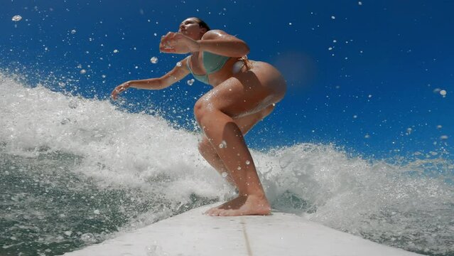Young woman surfing point of view riding ocean wave on short surfboard