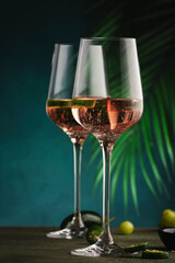 Rose pink wine with jalapeno pepper in wine glass, dark background, copy space