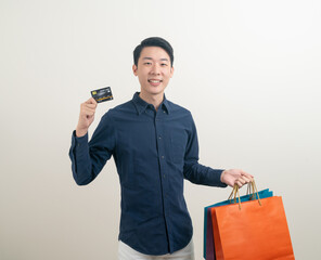 portrait young Asian man holding credit card and shopping bag