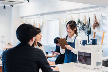 カフェで注文を取る若いスタッフ