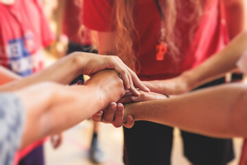 Team of kids children basketball players stacking hands in the court, sports team together holding...