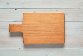 Wooden board on a wooden board. Cherry wood handmade wood chopping board on cool tone plank tabletop