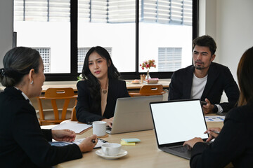 Business plan and strategy meeting with Diversity aged business people, using laptop, Empty screen of laptop.